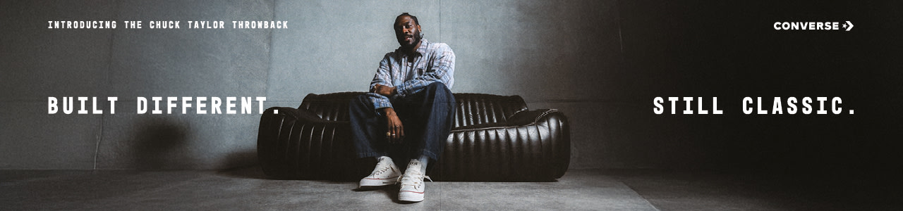 Promotional photography for the Converse 'Chuck Taylor Throwback' campaign featuring artist Knucks. The visuals highlight the footwear's design—notably the wider fit and oversized 'fat laces'—against an industrial concrete background with a black leather sofa. The campaign is tied together by the text: 'BUILT DIFFERENT. STILL CLASSIC.