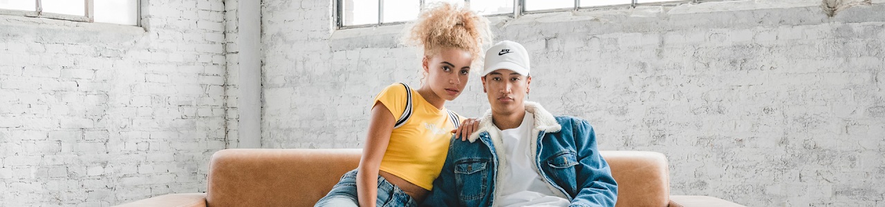 two people sitting on a brown couch.