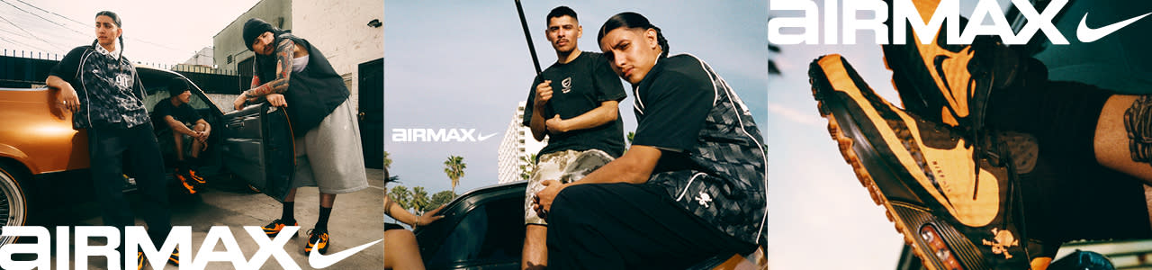 A split-screen Nike Air Max advertisement banner set outdoors under a clear sky. On the left side, two young men are looking toward the camera; one stands in the background wearing a black graphic t-shirt and camouflage pants while holding a flag pole, and the other sits in the foreground wearing a dark checkered short-sleeve button-up shirt featuring a small skull and crossbones logo. The word "AIRMAX" with the Nike swoosh is displayed in large white text across the top left. On the right side, a close-up, angled shot shows a black and mustard-yellow Nike Air Max sneaker with a visible air bubble in the heel and a small orange skull and crossbones graphic near the ankle.