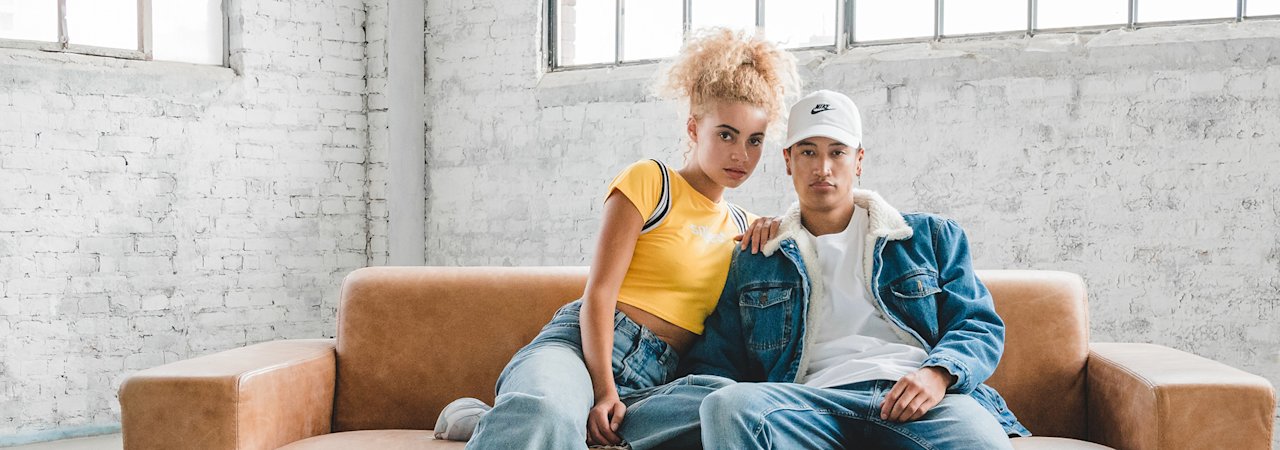 two people sitting on a brown couch.