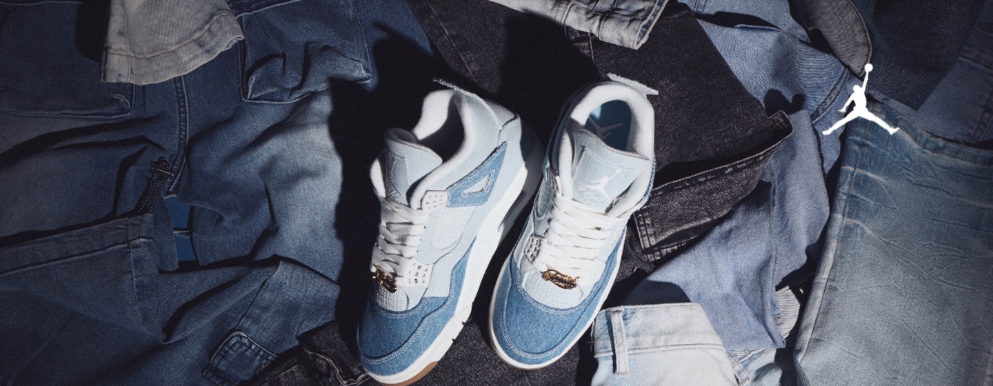 Jordan sneaker light blue and white laying on a bunch of jeans