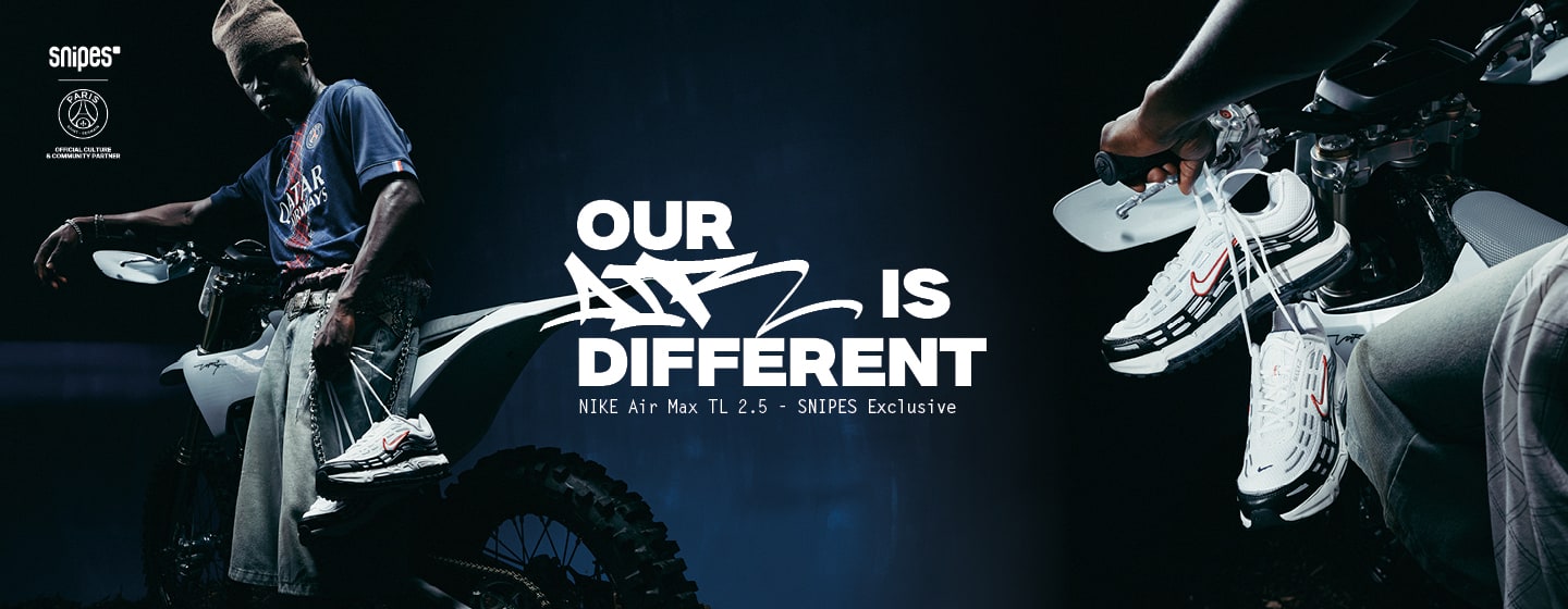 A promotional poster featuring a person holding up a white and gray Nike Air Max TL 2.5 sneaker with a red swoosh, standing in front of a motorcycle. Bold text at the top reads, "OUR AIR IS DIFFERENT," followed by "NIKE Air Max TL 2.5 - SNIPES Exclusive." The SNIPES logo and other branding appear at the bottom.