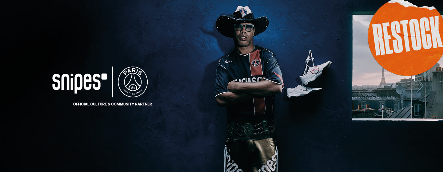 Ronaldinho wearing Thomson PSG Jersey and a cowboy hat. Nike T90 White sneakers hanging behind him on the wall. Restock round label written in white over an orange backround