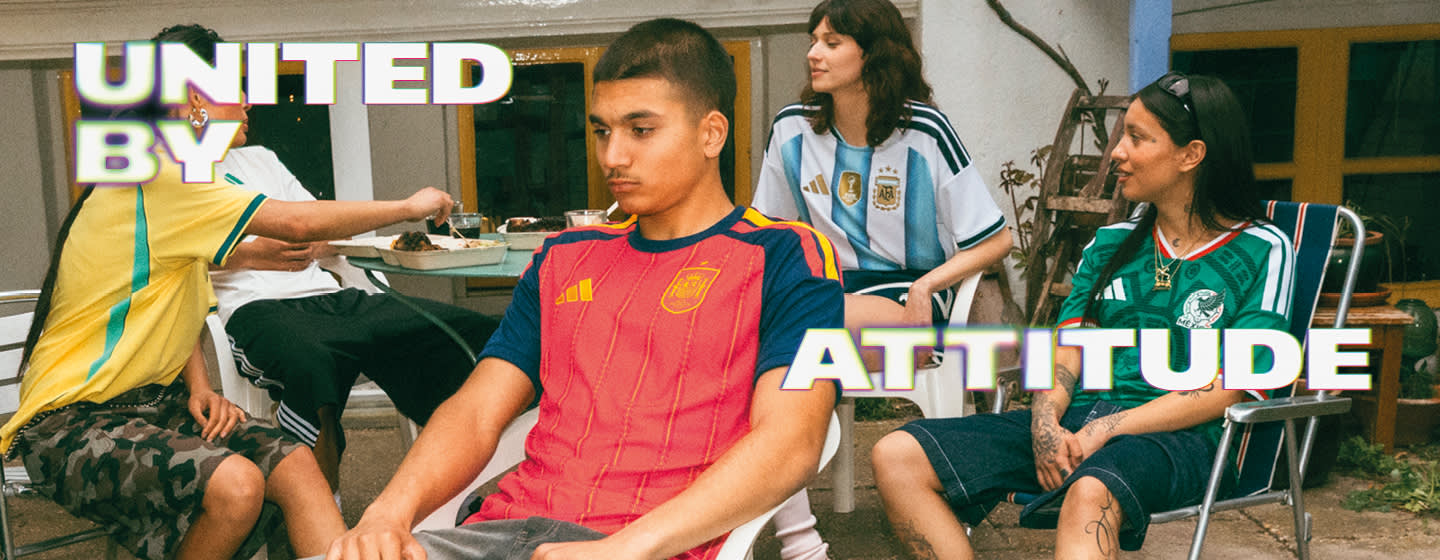 A promotional banner featuring five young individuals hanging out during a casual outdoor gathering in a backyard or patio setting. One person sits near a small charcoal grill with food cooking on it, while the others are seated around a patio table with food and drinks. They are all wearing different national football team jerseys, including France, Italy, Brazil, and Argentina. Large, stylized text overlays the image, with "UNITED BY" in the top-left corner and "ATTITUDE" across the bottom right, both featuring a bold white font with a soft neon glow.