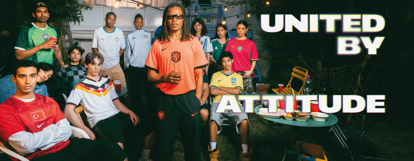 A promotional banner featuring five young individuals hanging out during a casual outdoor gathering in a backyard or patio setting. One person sits near a small charcoal grill with food cooking on it, while the others are seated around a patio table with food and drinks. They are all wearing different national football team jerseys, including France, Italy, Brazil, and Argentina. Large, stylized text overlays the image, with "UNITED BY" in the top-left corner and "ATTITUDE" across the bottom right, both featuring a bold white font with a soft neon glow.