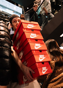 man holding multiple NIKE shoes cartons