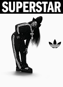 black and white image of rapper Missy Elliot wearing black adidas Superstar II sneakers and black adidas tracksuit