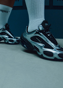 foot wearing long white sock and silver nike air max muse sneaker