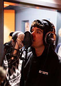 Photo of guy talking into a recording microphone at the snipes hiphop studio