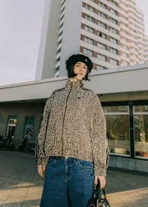 Women wearing track jacket with animal print and a black cap