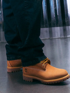 Model wearing autumn streetwear clothing and shoes, while standing in a silver futuristic setting.