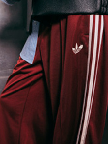 Model wearing autumn streetwear clothing and shoes, while standing in a silver futuristic setting.