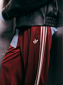 Model wearing autumn streetwear clothing and shoes, while standing in a silver futuristic setting.