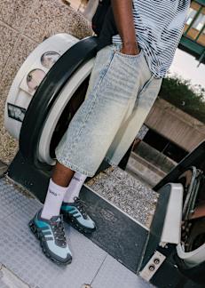 Guy wearing baggy short Jeans and Snipes socks in adidas black sneakers