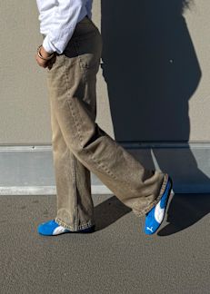 Girl in the street wearing yellow speecat shoes and a yellow jersey 