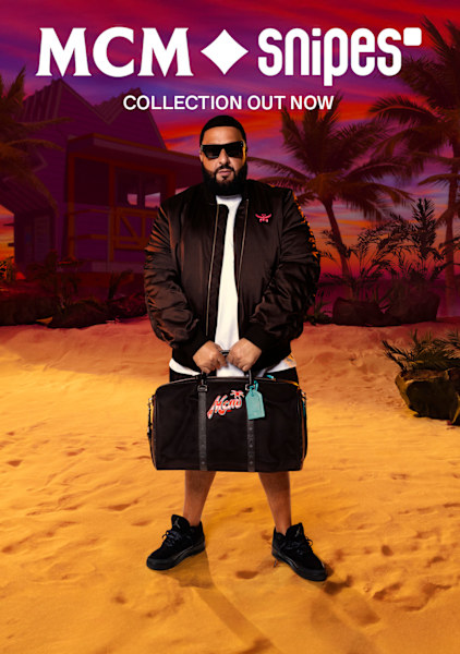 DJ Khaled wearing MCM x SNIPES bomber jacket and holding the branded black bag