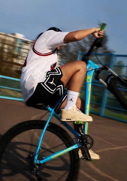 guy wearing Jordan Flight Court beige riding a bike