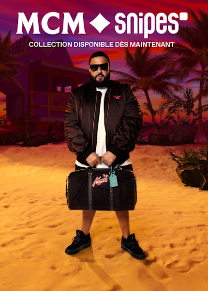 DJ Khaled wearing MCM x SNIPES bomber jacket and holding the branded black bag