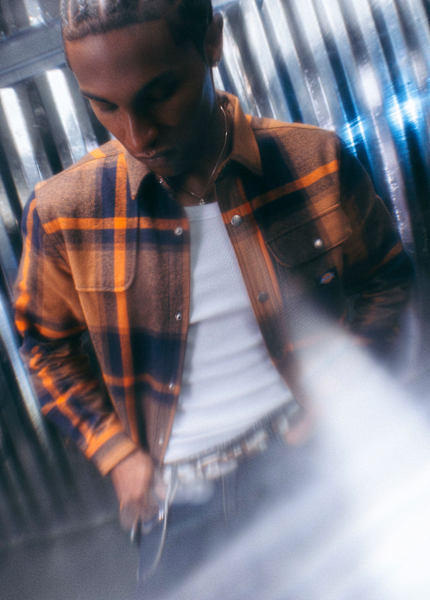 Model wearing autumn streetwear clothing, while standing in a silver futuristic setting.