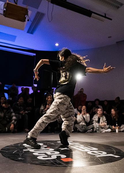 Girl dancing surrounded by spectators at a snipes dance competition