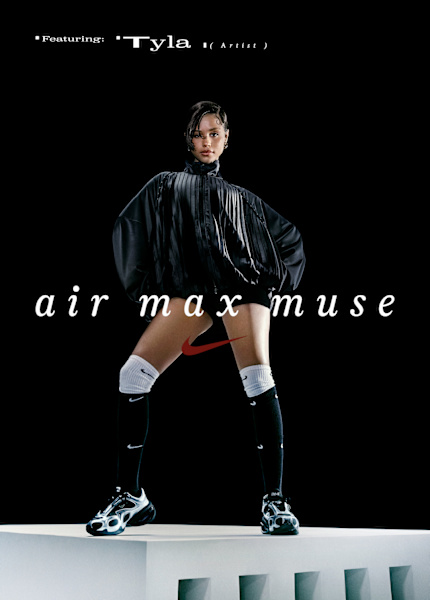 Artist Tyla poses confidently in a Nike ad campaign titled “Air Max Muse.” She wears a black oversized pleated jacket, black and white Nike knee-high socks, and black Nike Air Max sneakers. She stands on a white platform against a black background, with bold white and red text overlaying the image.