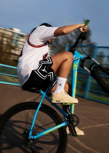 guy wearing Jordan Flight Court beige riding a bike