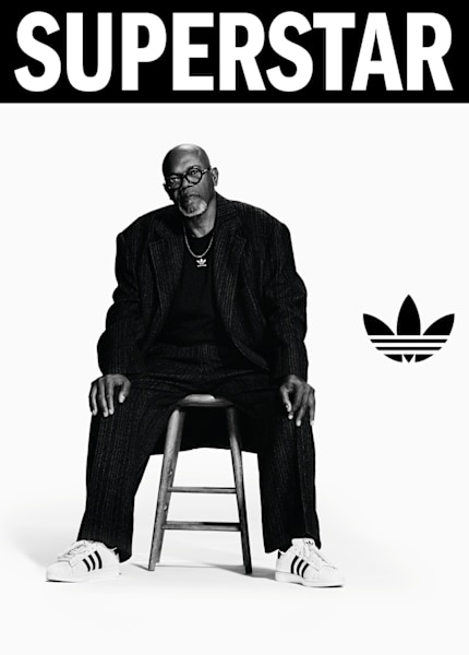 black and white image of actor Samuel L. Jackson wearing white adidas Superstar II sneakers and black suit