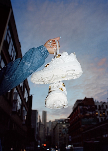 Girl holding a pair of Jordan white 