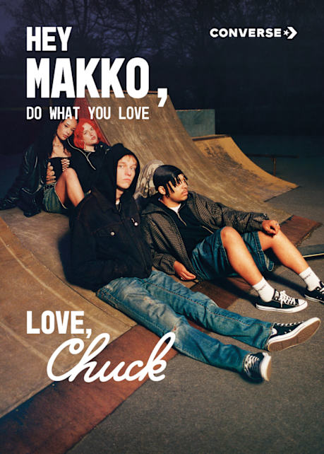 artist Makko sitting on the grund wearing black converse chuck
