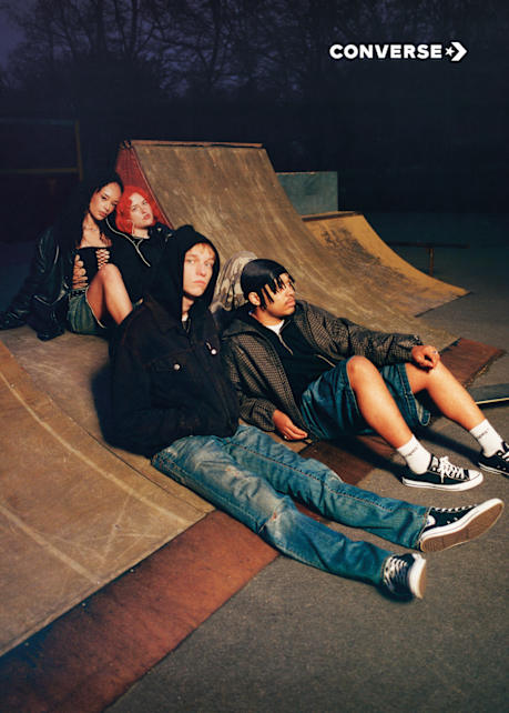 artist Makko sitting on the grund wearing black converse chuck