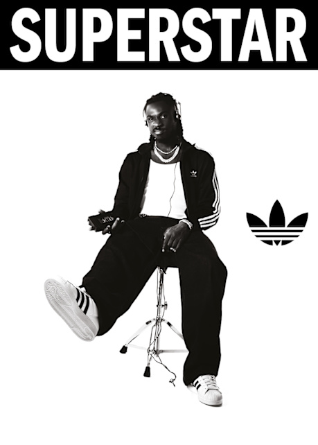 black and white image of athlete Moise Kean wearing black adidas Superstar II sneakers and black adidas tracksuit