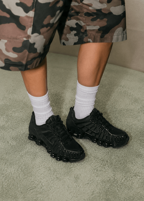 Nike Shox on Women Feet, camo pants at the top of the image, white socks