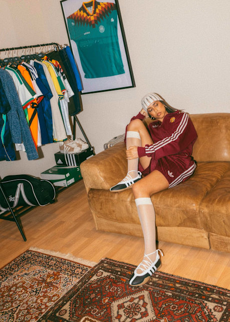 Model with Spain Tracksuit Jacket and Spain Shorts on a Couch