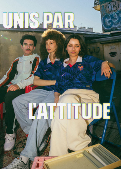 Wide banner featuring three smiling young adults on an urban rooftop, dressed in Nike France soccer apparel. Overlaid on the left and right in large, bold white text with a subtle yellow glow is the French phrase "UNIS PAR L'ATTITUDE". On the left, a man sits in a light-colored jacket with black and red accents. In the center and right, two women sit together wearing blue patterned France national team jerseys with the FFF rooster crest.
