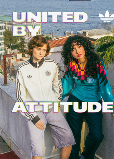 An promotional banner featuring five individuals posing outside a European-style cafe or storefront with a dark green facade. They are all wearing retro-style Adidas athletic apparel, including jerseys and jackets featuring the Germany national football team crest. On the left side of the banner, the text "UNITED BY" is displayed in a bold, white, stylized font with a soft neon glow. On the right side, the text "ATTITUDE" is written in the same font style, alongside a white Adidas Originals trefoil logo in the top right corner. The atmosphere is casual and relaxed, with the individuals sitting and standing around outdoor tables.