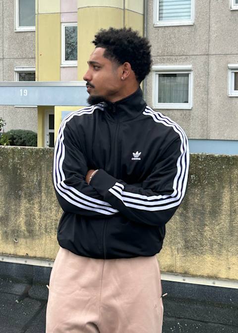 Guy wearing a black adidas trainjacket