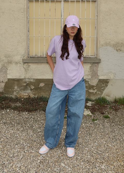 Girl wearing baggy clothes with a pink heat and shirt and oversize pants