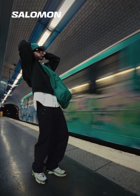 Men in front of a tram wears the salomon sneaker and holds his head