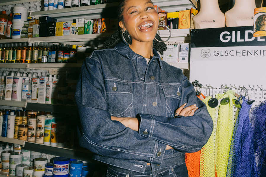 Season update styles woman in store wearing denim jacket & jeans