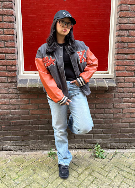 Men wearing denim jacket with flowers behind