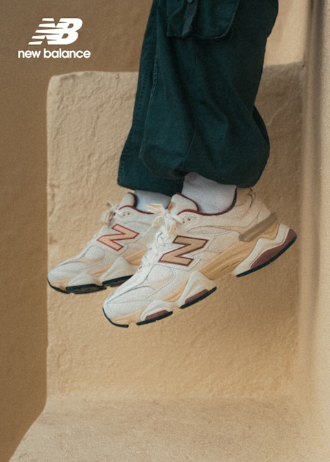 Feet wearing New Balance beige sneakers